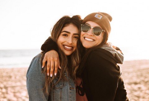 Two friends hugging at the beach.