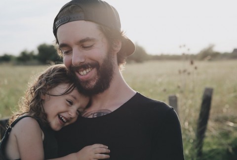 A father and child hug while sitting outside