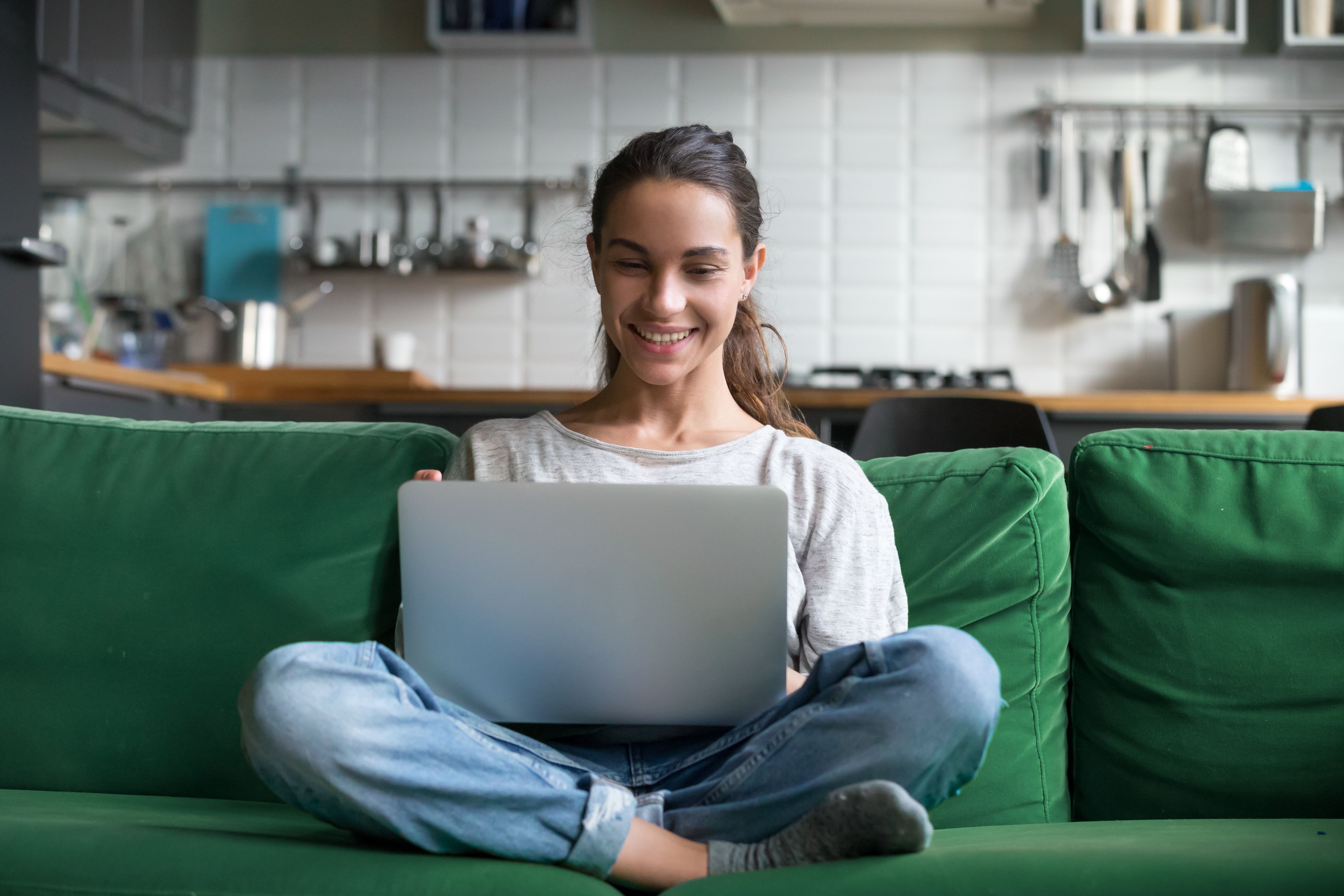 Person wearing a light coloured woolen jumper working on a Macbook Air